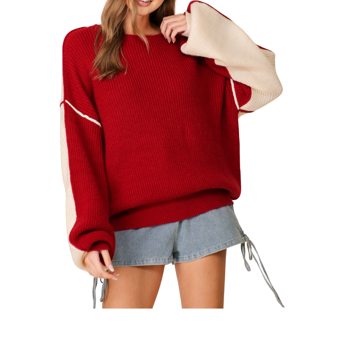 A person is wearing the Gameday Oversized Sweater by Lumiere in Crimson/Ivory from FASHION GO, styled with denim shorts.