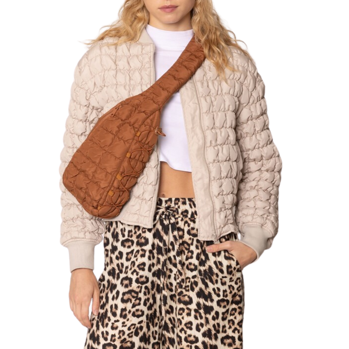 A person is sporting a quilted jacket, white cropped shirt, leopard print pants, and the chic Brielle Quilted Puffer Sling Bag by FASHION GO. The hands-free design is perfect for those on-the-go moments.