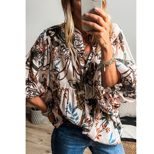 Person taking a mirror selfie in the Shewin White Boho Print Lantern Sleeve V Neck Blouse, featuring floral patterns and elegantly paired with blue jeans.