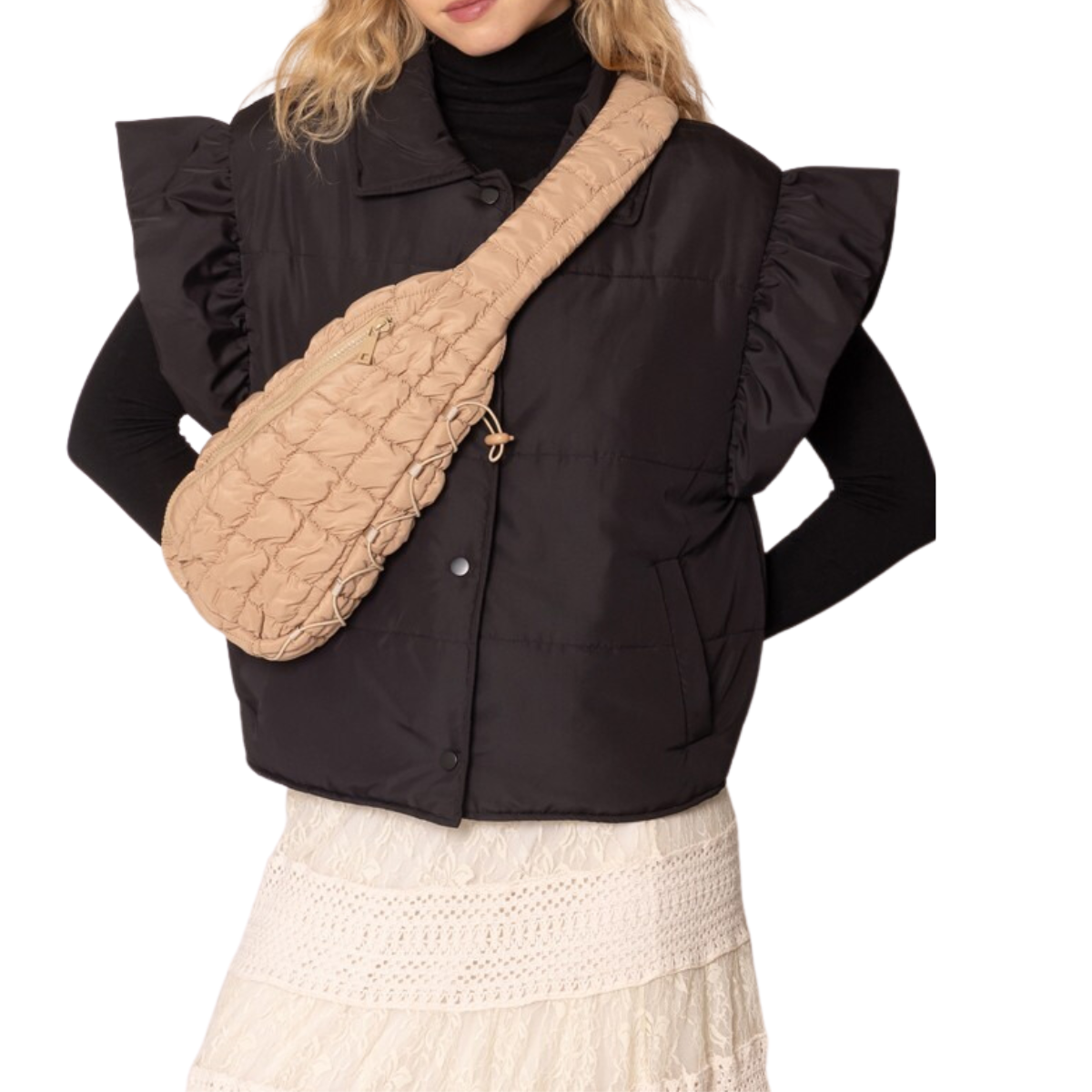 Someone wearing a black puffy vest with ruffled sleeves and a white lace skirt carries the Brielle Quilted Puffer Sling Bag from FASHION GO in beige.