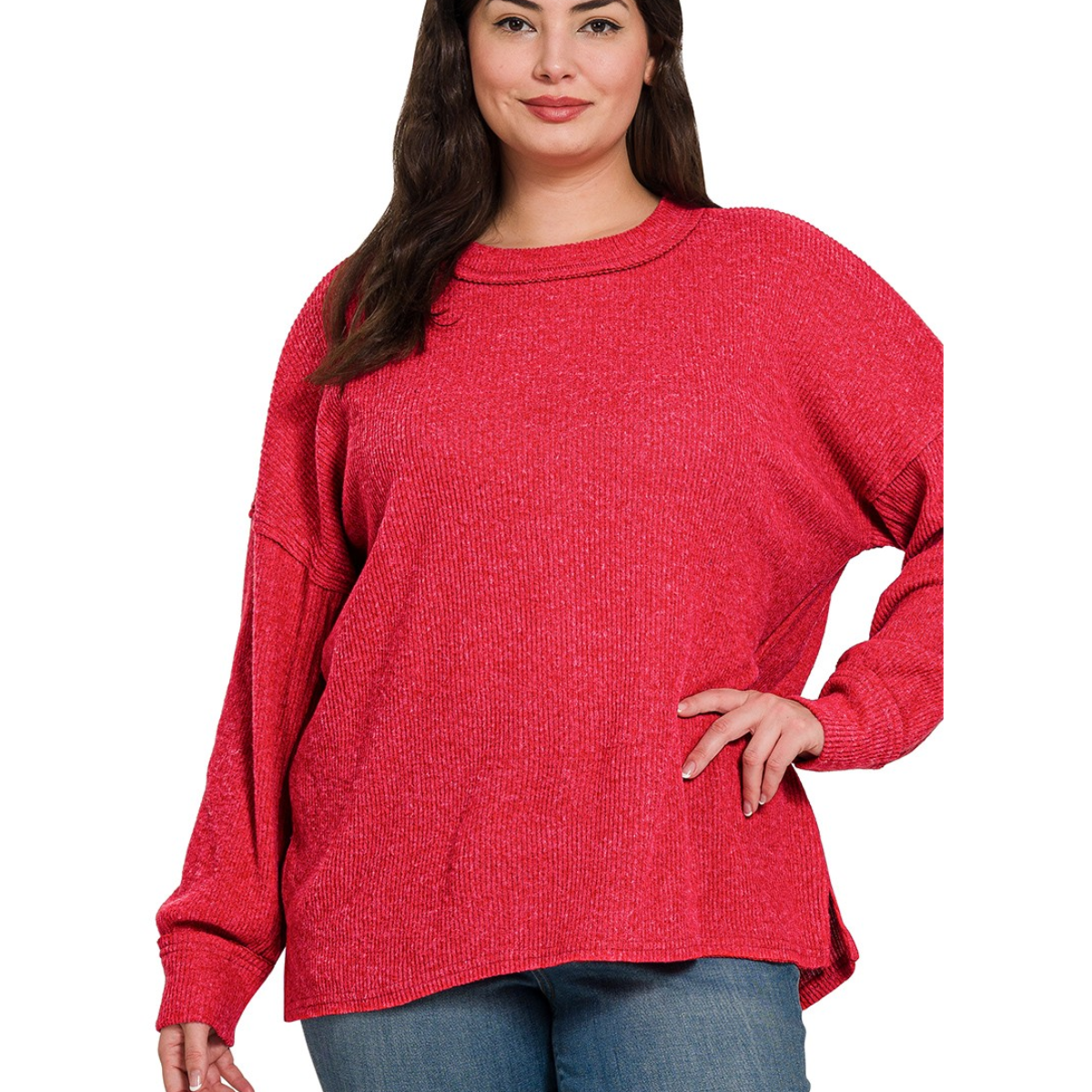 A woman in a Zenana Brushed Ribbed Hacci Drop Shoulder Sweater and blue jeans stands against a white background.