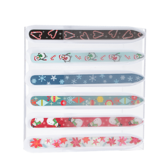 The Holiday Glass Nail File set by Ganz Inc includes six files, each adorned with festive designs such as hearts, penguins, snowflakes, gifts, snowmen, and red flowers, all neatly arranged in a clear plastic holder.