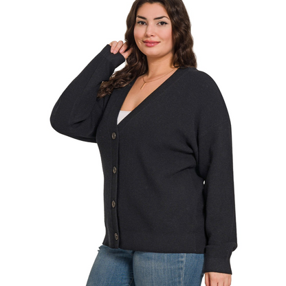 A woman models the Zenana Cardigan Sweater over a white top and blue jeans, smiling while standing against a plain white background.