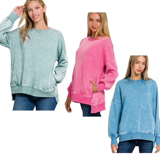 Three women wear FASHION GO Acid Washed Fleece Hi-Low Pullovers in pastel green, pink, and blue with jeans, standing against a white background.