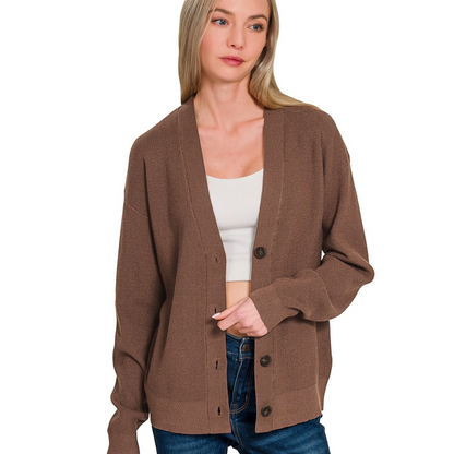 A woman wears a Zenana Cardigan Sweater in brown over a white crop top and blue jeans, standing against a white background.