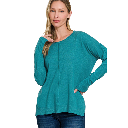 A woman wears the FASHION GO Viscose Front Seam Round-neck Sweater in teal with blue jeans, standing against a white background.