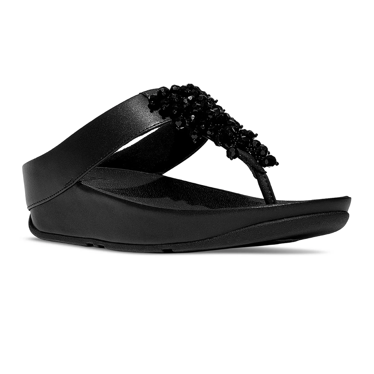 The Rumba Beaded Toe Post Sandal by FitFlop, from FITFLOP USA LLC, is a black platform thong sandal with a wide strap detailed in textured black embellishments, shown from the side against a white background for chic style and comfort.