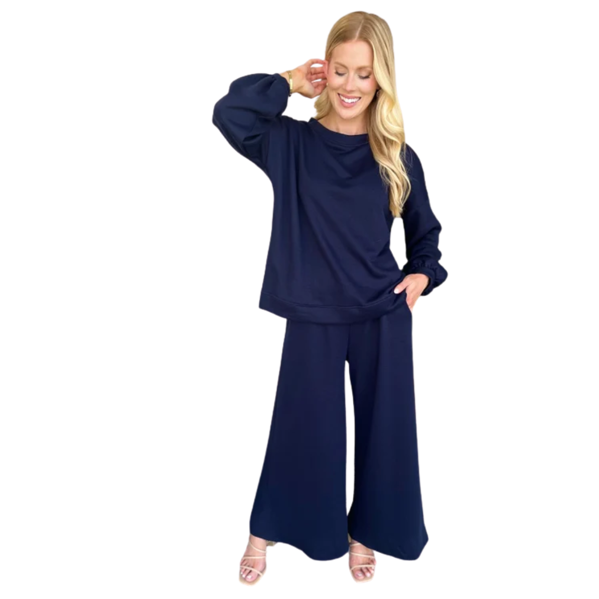 A woman wears the Carole Christian Terry Wide Leg Set in Navy, featuring a relaxed fit top and wide-leg pants, standing and smiling with one hand touching her head. Main image