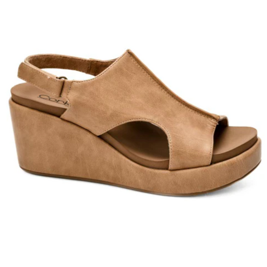 The Carley Wedge in Caramel by Corky's, from CORKY'S FOOTWEAR INC, is the epitome of comfortable shoes. Featuring a thick sole and cutout design with an open toe and heel strap, this stylish sandal boasts a 3-inch heel that effortlessly combines fashion with comfort.