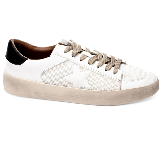 The Another Round Sneaker by Corky's from CORKY'S FOOTWEAR INC, featuring a chic white design with a light gray star, beige laces, and a black heel accent, is placed against a white background.