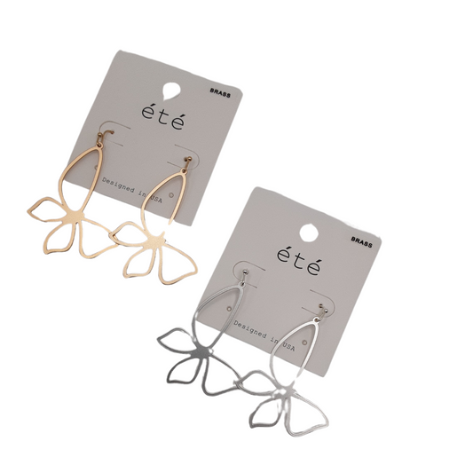 Two pairs of earrings designed like butterflies with open metal work, one pair in gold and the other in silver, attached to cards labeled "été," from the SPECIAL EFFECTS brand.