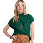 A woman wearing the Fashiongo Patch Pocket Ribbed Knit Sweater in green and a brown skirt, accessorized with a wooden pendant necklace and bracelet, stands against a white background.
