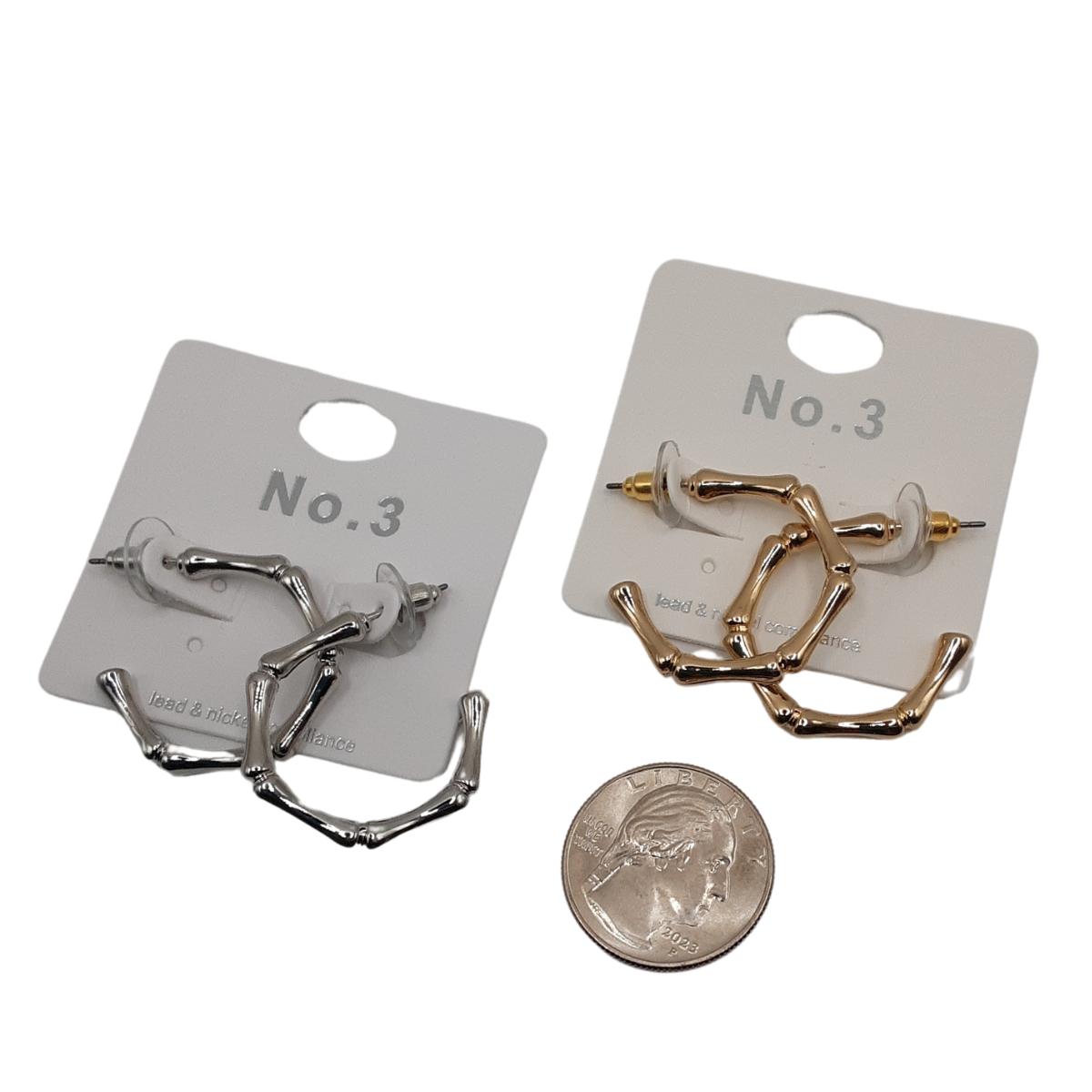 Two pairs of the Bamboo Look Hoop Earrings from SPECIAL EFFECTS, one in silver and one in gold, each with a 1-inch diameter, are elegantly presented on display cards labeled "No. 3." A quarter is placed below for size reference. Main image