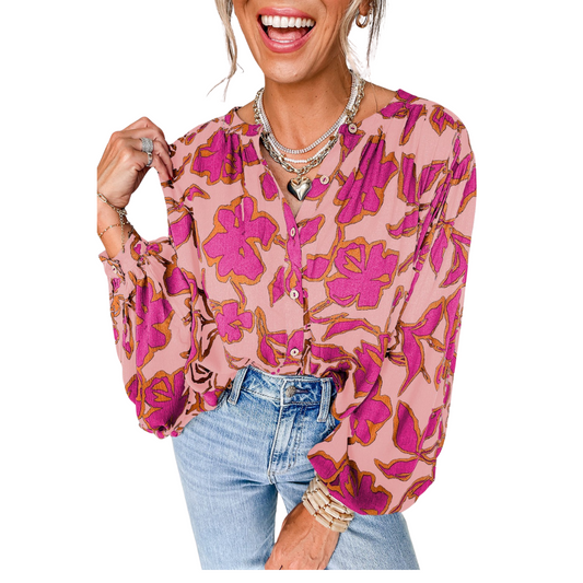 A woman smiles and poses with one hand on her collar, wearing the FASHION GO Floral Batwing Sleeve Button Blouse, blue jeans, layered necklaces, and bracelets.