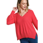 A woman wears the FASHION GO V-Neck Long Sleeve Sweater with Side Slits in coral-pink, paired with blue jeans, standing against a white background.
