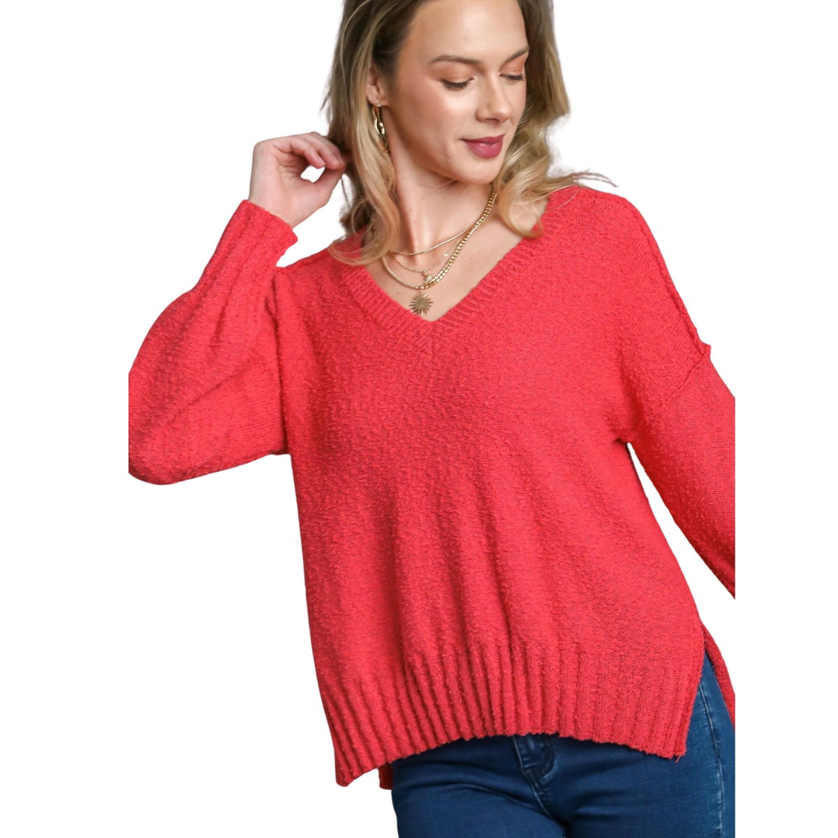 A woman wears the FASHION GO V-Neck Long Sleeve Sweater with Side Slits in coral-pink, paired with blue jeans, standing against a white background.