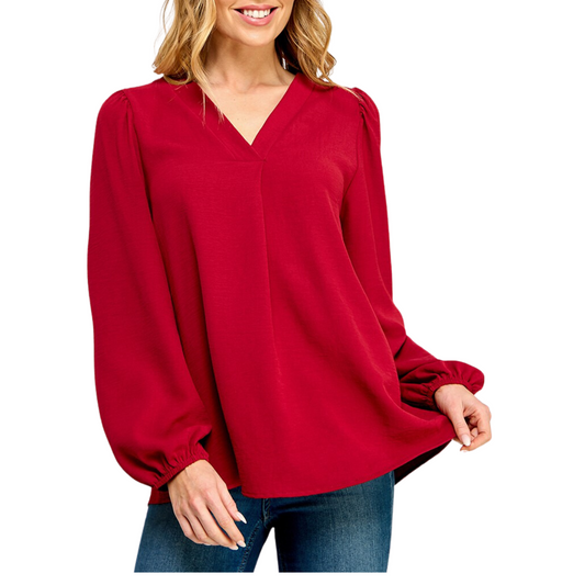 A person is wearing a V-Neck Long Sleeve Blouse in Red by FASHION GO, paired with blue jeans.