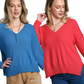 Two women stand side by side: one in the FASHION GO V-Neck Long Sleeve Sweater with Side Slits and tan pants, the other in a red soft knit sweater and blue jeans.