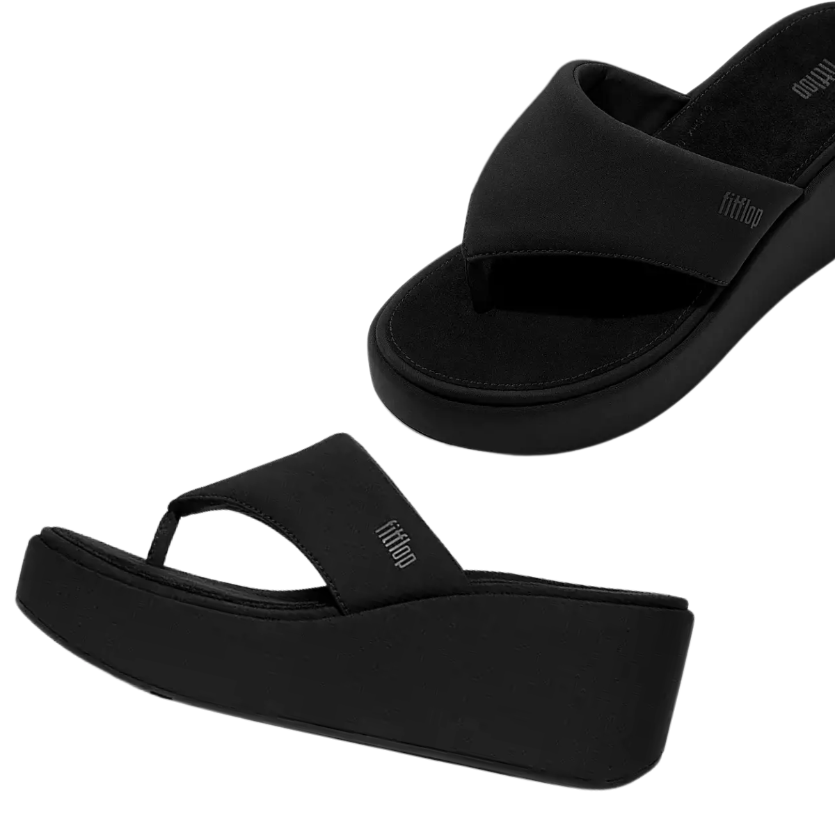The fit flop Platfforms Wedge Flip-Flops in black feature thick soles, wide crisscross straps, and a CushX midsole for comfort, shown against a white background.