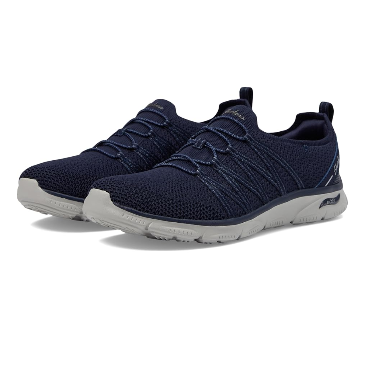 The Arch Fit Sunny in Navy by Skechers from SKECHERS USA INC are a pair of navy blue athletic shoes with grey soles, featuring a mesh upper, lace closures, and pull tabs on the heels. Enhanced with Air Cooled Memory Foam for all-day comfort, they're set against a plain white background.