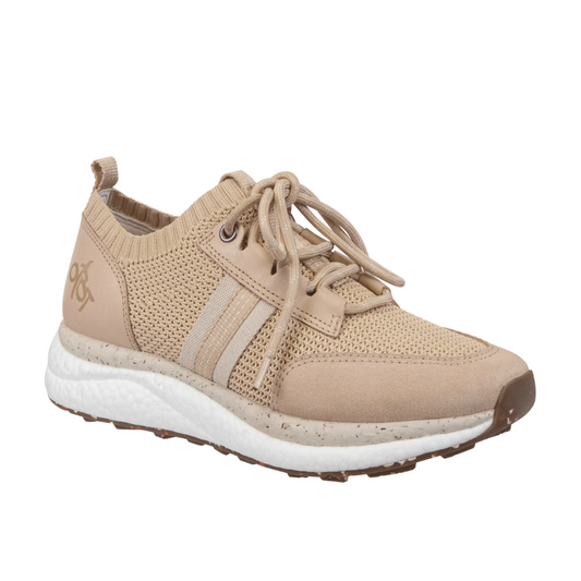 The Speed Sneaker in Blush by OTBT is a tan athletic sneaker featuring beige laces, knitted fabric, and a recycled rubber lug sole with white speckles, perfect for women's sneaker enthusiasts.