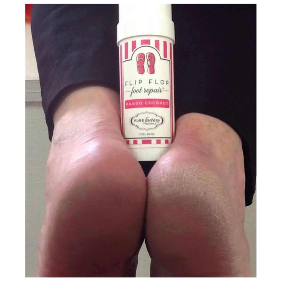 Close-up of two feet with a 1.75oz Flip Flop Essential Oils Foot Repair bottle in mango coconut scent by PUREfactory Naturals placed between the heels.