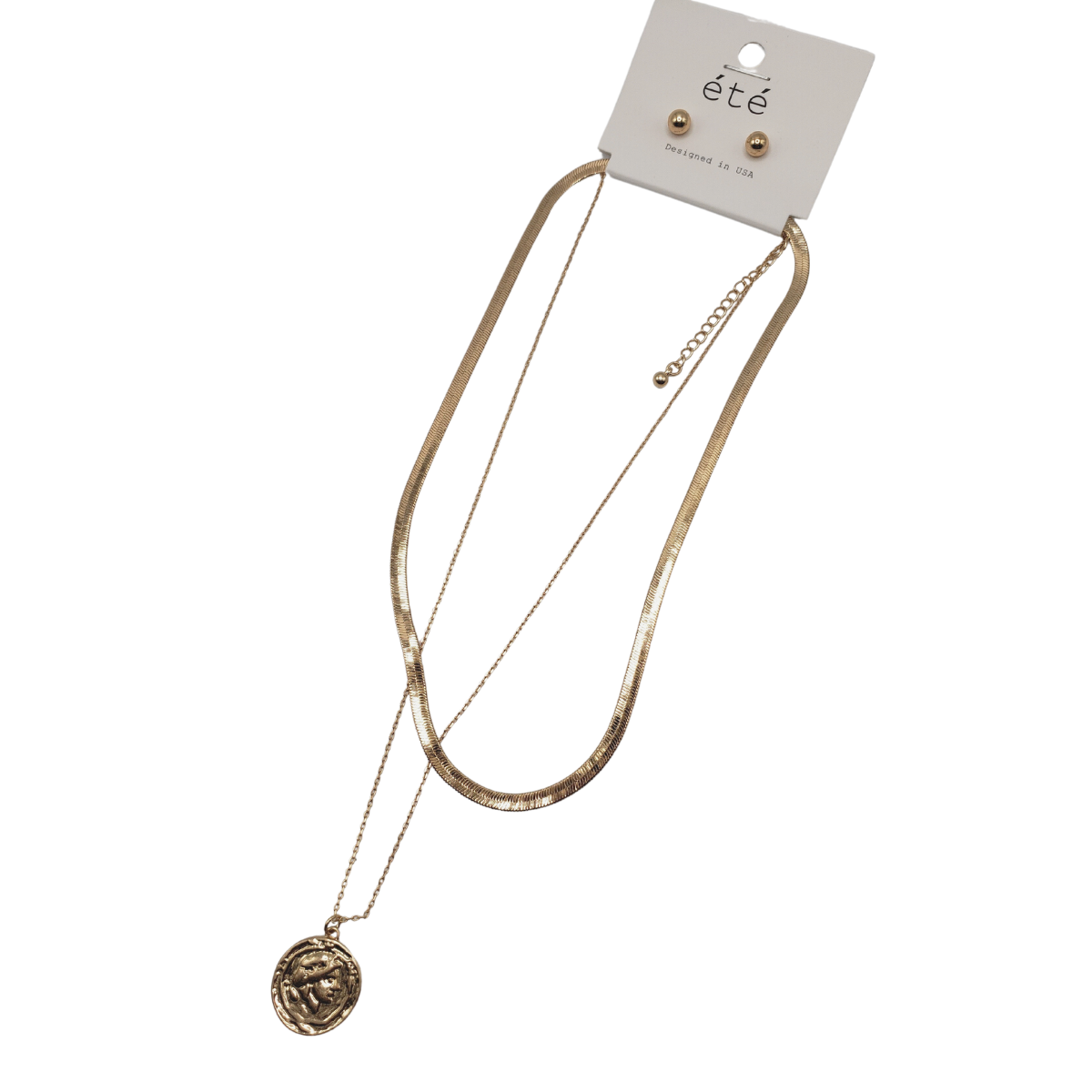 The 3 Row Chain Necklace by SPECIAL EFFECTS features a medallion pendant and adjustable length, paired with small gold studs on a display card labeled "été," with a charming coin disc accent.