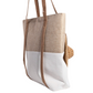 The FASHION GO Large Canvas Tote Bag features a stylish two-tone design with a beige upper, white lower, and long brown handles. It includes an external pocket ideal for storing items, making it perfect for carrying hats on the go.