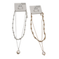 The SPECIAL EFFECTS set features a silver and gold chain necklace with teardrop pendants on white backing cards labeled "été," "Water Resistant," and "Designed in USA," perfectly complemented by pearl stud earrings for a complete look.