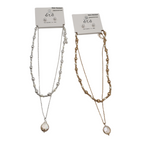 The SPECIAL EFFECTS set features a silver and gold chain necklace with teardrop pendants on white backing cards labeled "été," "Water Resistant," and "Designed in USA," perfectly complemented by pearl stud earrings for a complete look.