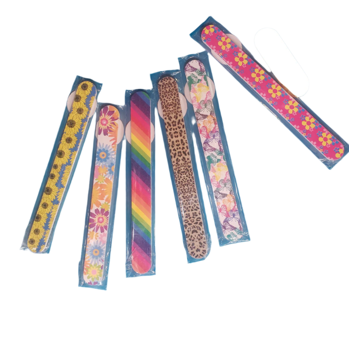 Six vibrant and patterned PATTERNED NAIL FILE EMORY BOARD files from GIFTCRAFT spread out, showcasing designs such as sunflowers, daisies, rainbow, leopard print, floral, and retro flowers. Each is housed in its own blue plastic sleeve.