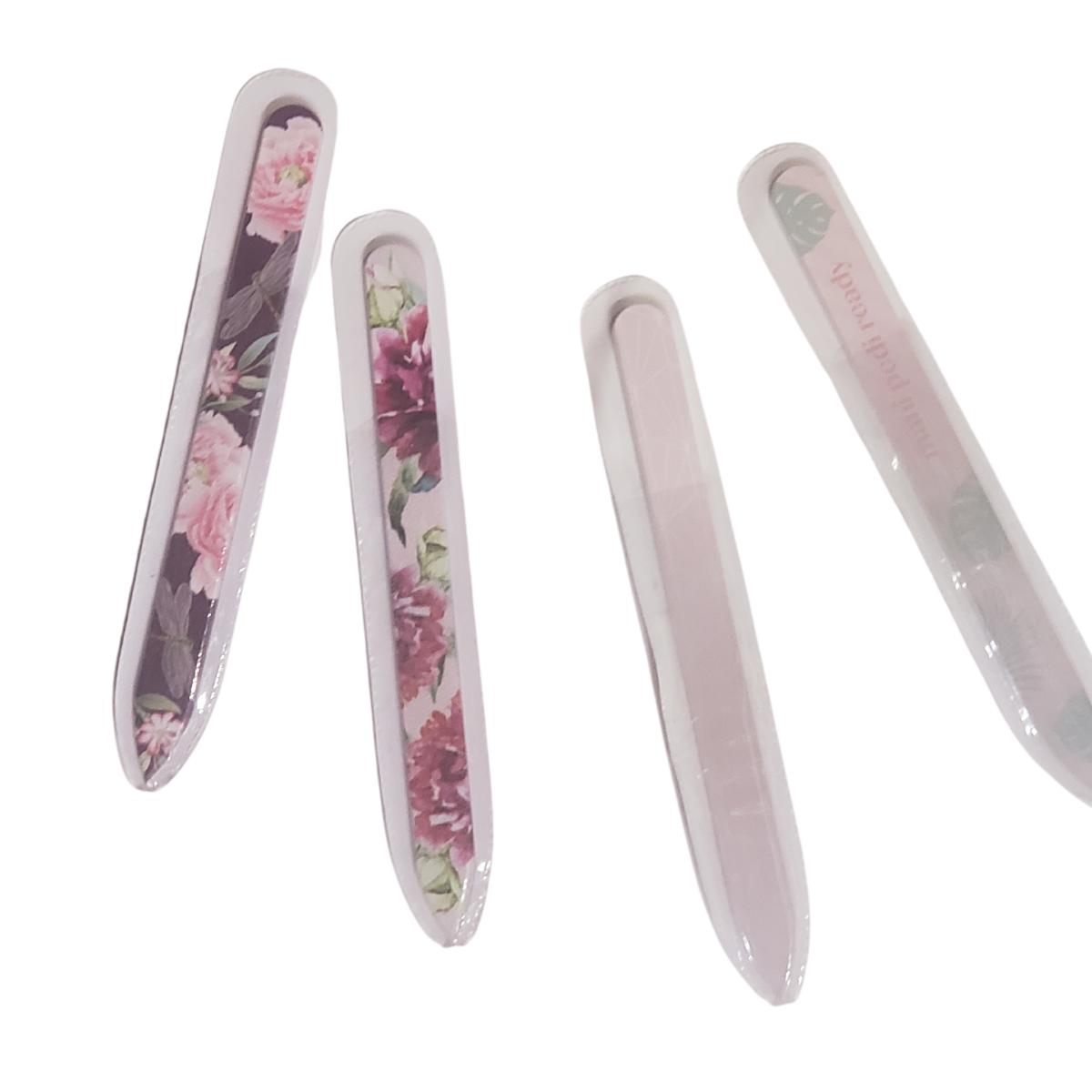 Four Glass Nail File Assorted from DM MERCHANDISING INC, featuring floral designs, are placed on a white surface.