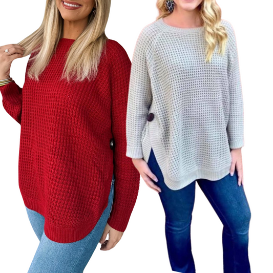 Two women in jeans and Lauren sweaters from Ronnie Salloway & Co Inc smile. One wears a red crew neck sweater with long blonde hair, and the other dons a gray side-button sweater with wavy blonde hair.