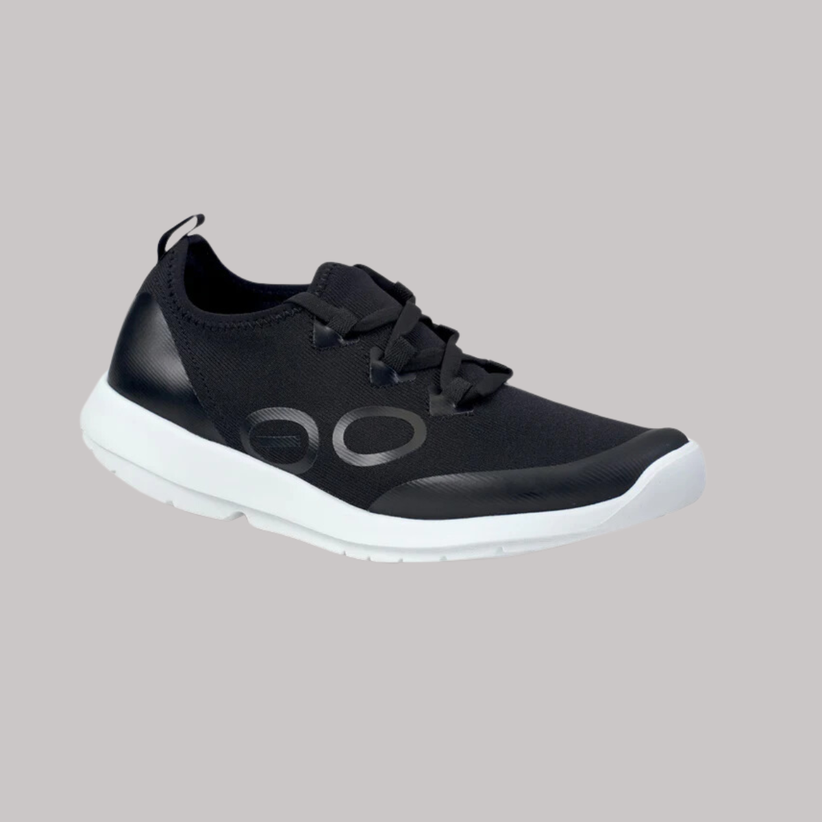 Introducing the Oofos Sports Lace Women's in Black/White by OOFOS LLC, a stylish sneaker featuring a sleek design. It is equipped with a FibreFlex upper for remarkable flexibility, finished with a white sole and lace-up closure, making it perfect for active recovery and everyday comfort.