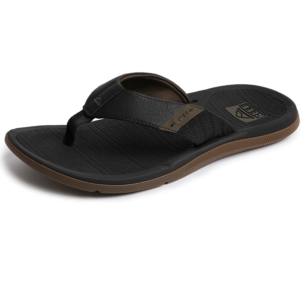 The Santa Anna Men's Flip-Flop in Black by REEF features a textured sole with brown accents and a branded logo on the strap. Designed with water-friendly materials, this flip-flop offers enhanced arch support for all-day comfort.