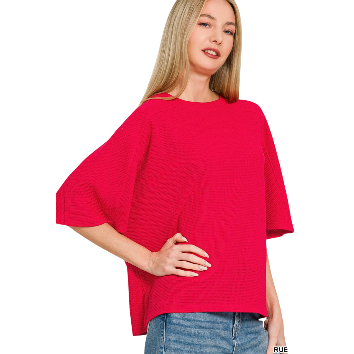 A woman with long blonde hair wears the Zenana Double Knit Short Sleeve Top—a bright red, loose-fitting everyday essential—paired with blue jeans, standing with one hand on her hip against a white background.