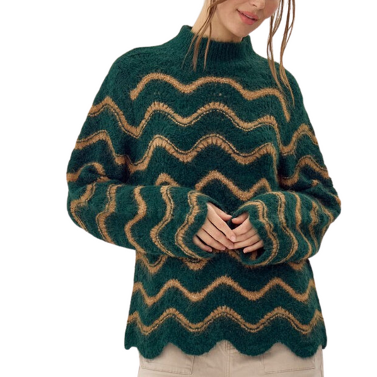 A person stands against a white background wearing the Wavy Stripe Stitched Knit Sweater by FASHION GO, featuring wavy orange and tan stripes on a green pullover top.