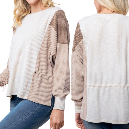 Front and back view of a woman wearing FASHION GO's "It's a Cinch Top in Ivory Combo," a lightweight, color-blocked ribbed sweater in white and beige tones, paired with blue jeans.