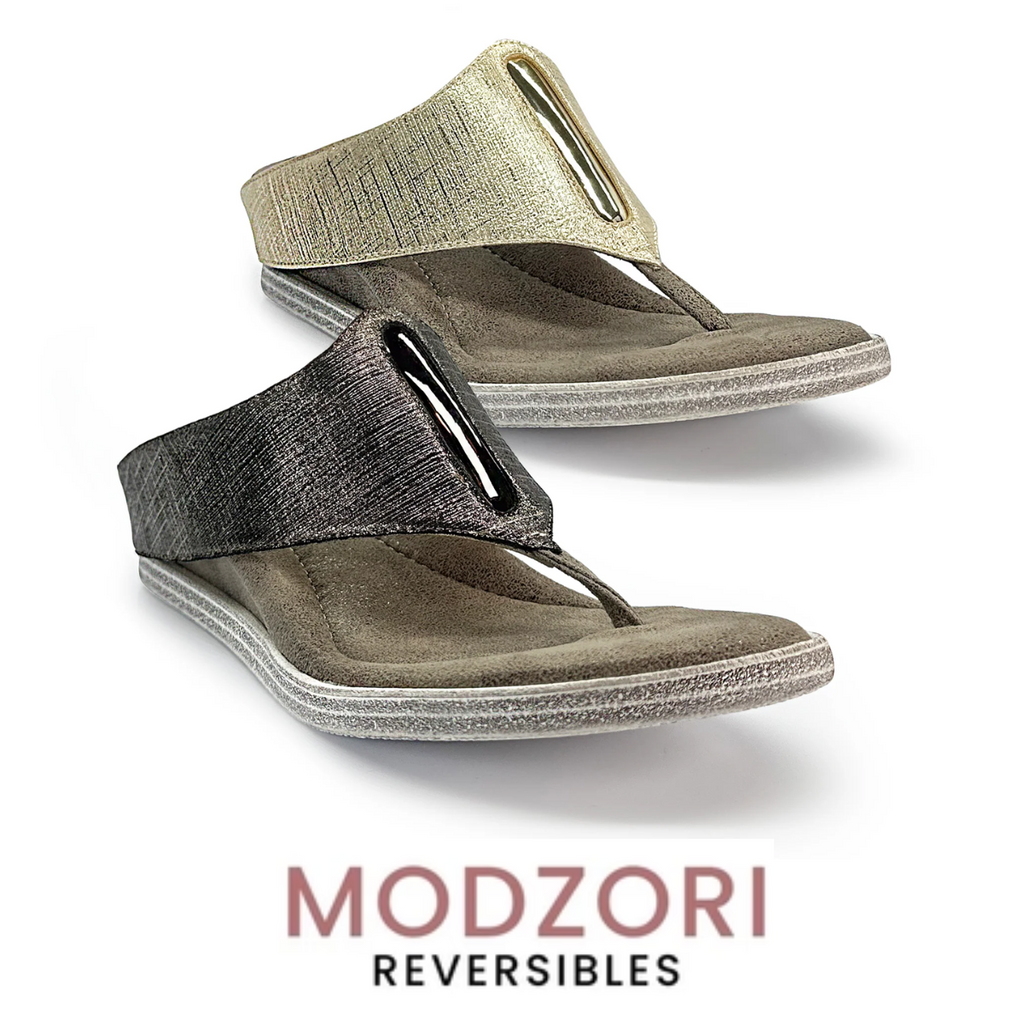 The Iris #1 Reversible Wedge Sandal by Flipflops & Whatnots features a textured strap and metal accent, crafted from vegan leather. With gold to pewter reversible technology, "Modzori Reversibles" proudly showcases its innovative design.