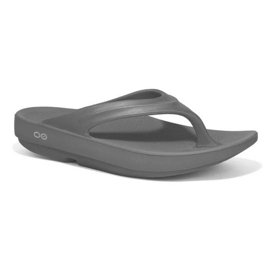 The Oofos Oolala Women's Recovery Flip Flop in Slate Grey by OOFOS LLC provides comfort with its OOfoam technology, thick sole, and simple thong strap, ideal for stress reduction.