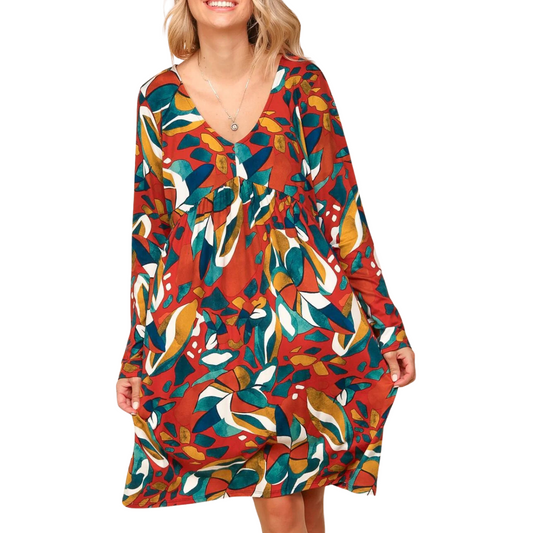 Someone is wearing the Rust Babydoll Abstract Print Dress from Bloom Wholesale, showcasing its colorful pattern against a plain background, elegantly paired with sturdy boots.