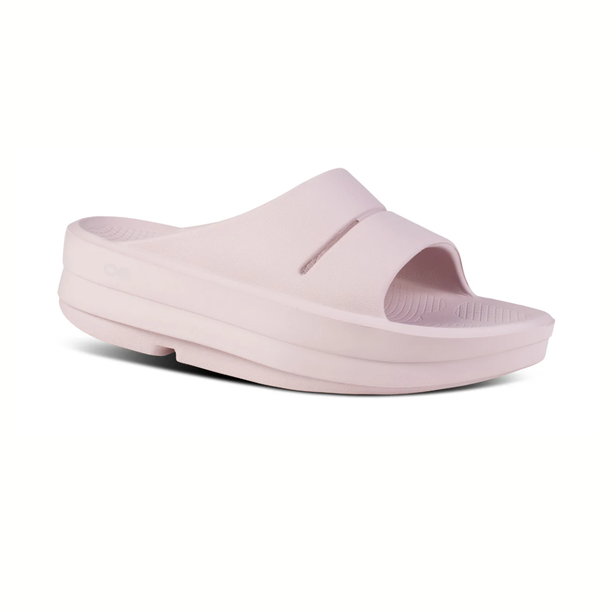 The OOFOS LLC Oomega Ooahh Slide in Stardust is a light pink open-toe slide with a wide strap and a thick OOfoam™ sole, shown on a white background.