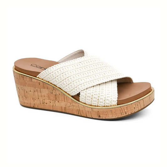 The Peace Out Wedge Sandal in Ivory by Corky's features crisscross white woven straps and a cork sole, making it the perfect stylish summer footwear from CORKY'S FOOTWEAR INC.
