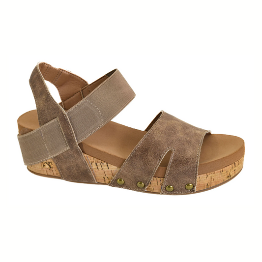 The Better with Time Wedge Sandal in Tan by CORKY'S FOOTWEAR INC features a cork wedge heel, two wide top straps, an ankle strap with hook-and-loop closure, metal rivet accents at the toe, and a comfy insole for all-day wear.