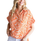 A woman wears the FASHION GO Tiger Print Collared Button Up Top with ruched shoulders and short sleeves, styled with light-colored pants.
