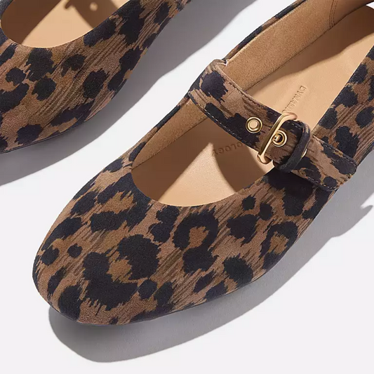 Close-up of Fit Flops' Delicato Leather Mary Janes in Leopard—comfortable nappa leather flats with a single strap and gold buckle, showcased on a neutral background.