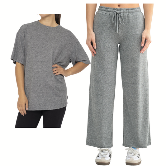 Two people model the Mono B Brushed Hacci Boyfriend Tee and Wide Leg Pant Set: one in an oversized tee with black pants, the other wearing wide-leg lounge pants with sneakers. Both pieces are from Mono B.