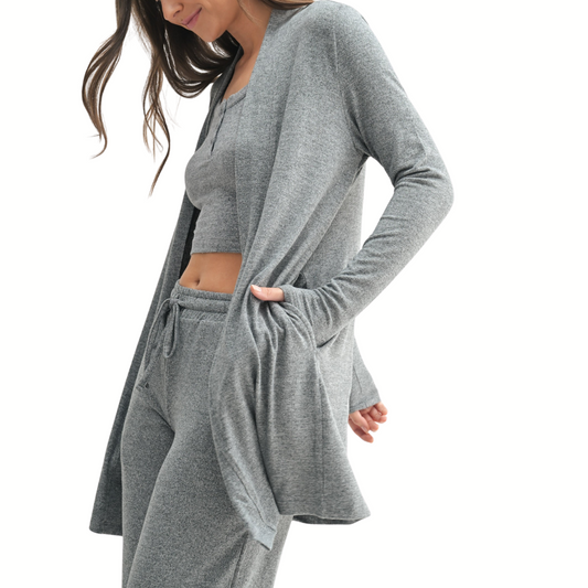 A woman wears the Mono B Brushed Hacci Open Cardigan as part of a coordinated light gray loungewear set with a crop top and drawstring pants, set against a white background.