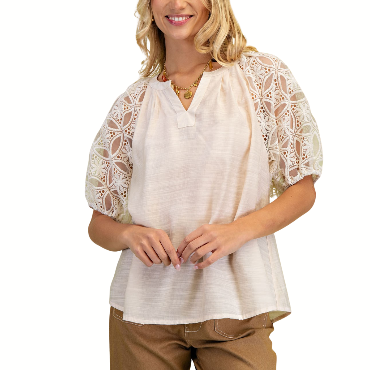 A woman models the Gigio Lace Sleeve Top With Split Neck, featuring cream floral balloon lace sleeves, paired with brown pants against a white background.