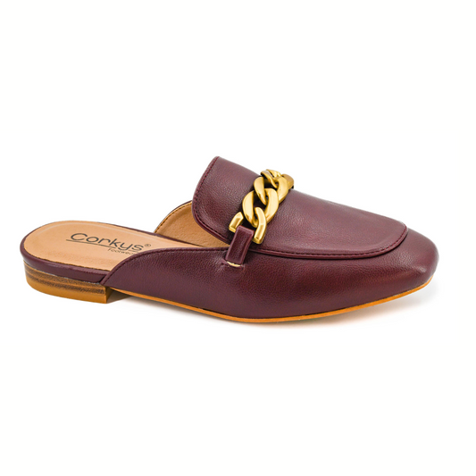The Keepsake Open Back Mule by CORKY'S FOOTWEAR features maroon faux leather, a flat heel, tan sole, and a striking gold chain accent across the upper for stylish flair.